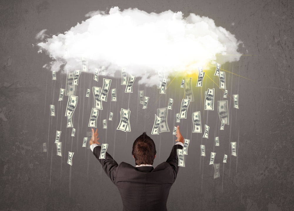 Business man in suit looking at cloud with falling money and sun