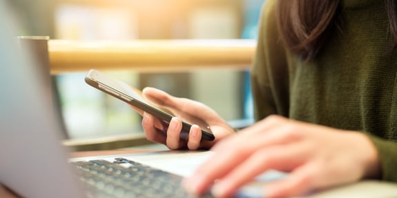 Woman connecting cellphone and laptop computer-185481-edited