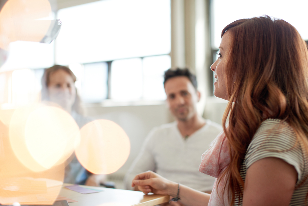 Unposed group of creative business people in an open concept office brainstorming their next project.-1